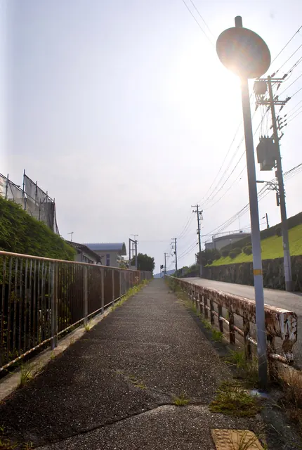 古い手すりとフェンスに沿って、遠くまでまっすぐ続く歩道