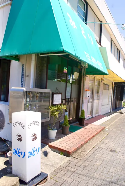 緑の日よけとパフェの見本のケースが並ぶ、昔ながらの喫茶店