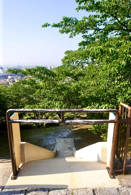 木々に囲まれた公園の、町を見下ろす手すり