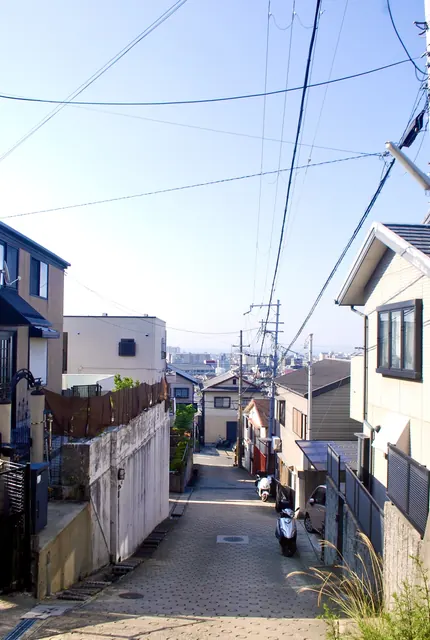 坂の上から、家々の屋根の向こうに街並みを見下ろす風景