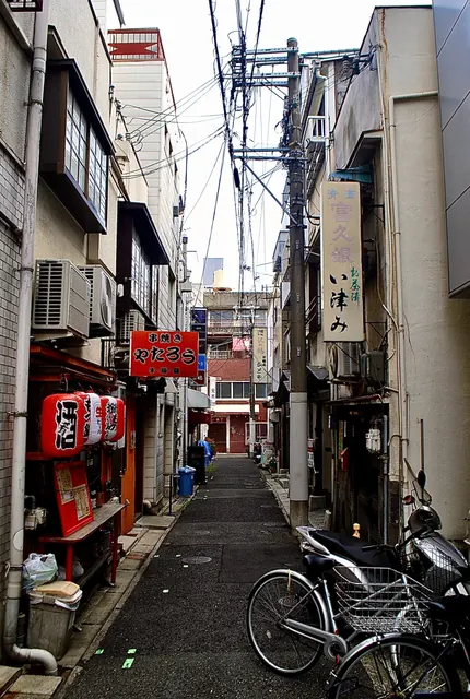 赤い提灯と「串焼き やたろう」の看板が並ぶ、細い路地