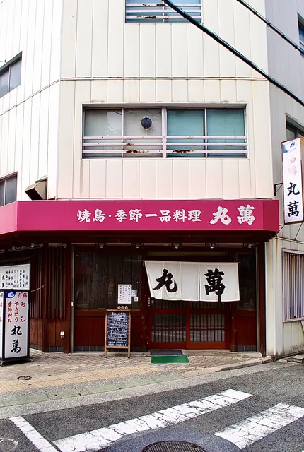 ピンクの日よけと大きなのれんの、焼き鳥・一品料理の店