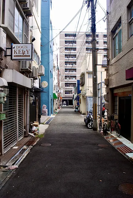 青い壁の店や看板が並ぶ、奥へまっすぐ続く細い路地