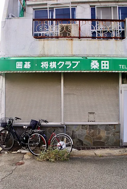 緑の日よけに「囲碁・将棋クラブ」と書かれた、シャッターの建物
