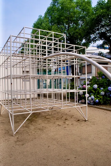 白いジャングルジムと、青やむらさきのあじさいが咲く公園