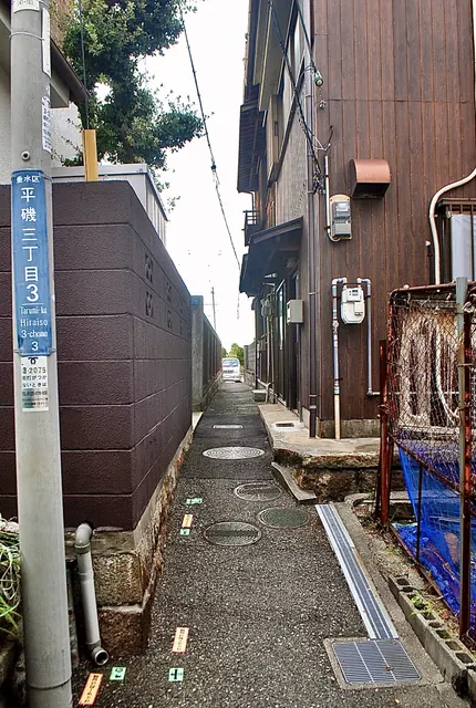 町名表示のある電柱の先に、家々のあいだをまっすぐ続く路地
