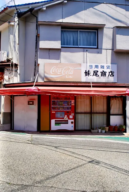 赤い日よけと古いコカ・コーラの看板のある、昔ながらの商店