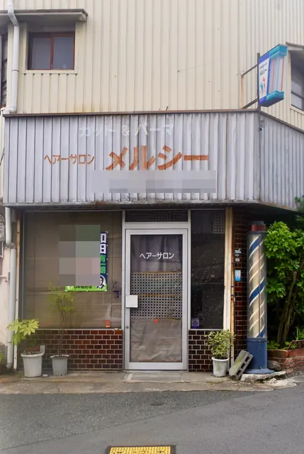 ペンキ文字の看板と赤白青のサインポールがある、昔ながらのヘアーサロン