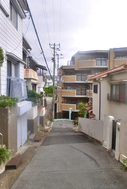 家々とマンションのあいだを、上へ続く細い坂道