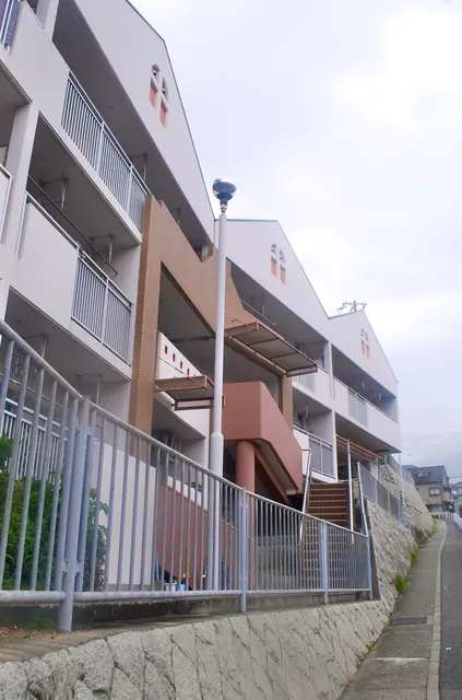 坂道に沿って、段々に建つマンションと手すりの続く道