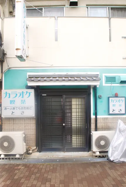 瓦屋根のひさしと格子戸の、カラオケ喫茶の店先