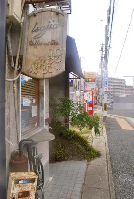 彫刻の入った木の看板がかかる、小さなカフェの窓辺