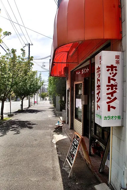 赤い日よけと「喫茶 ホットポイント」の縦看板