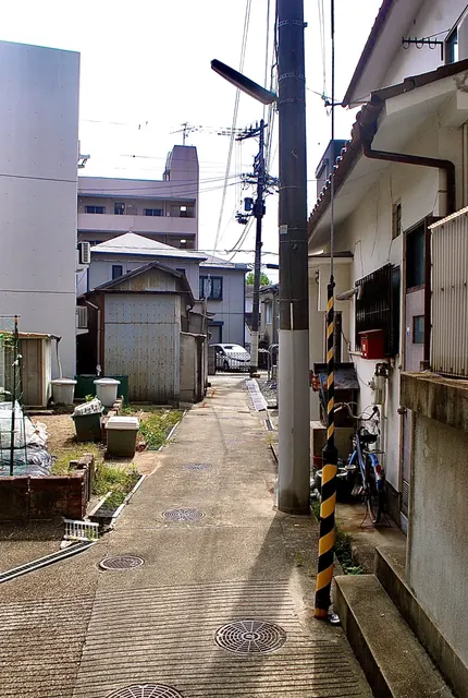 建物と塀のあいだを、奥へ続く細い路地