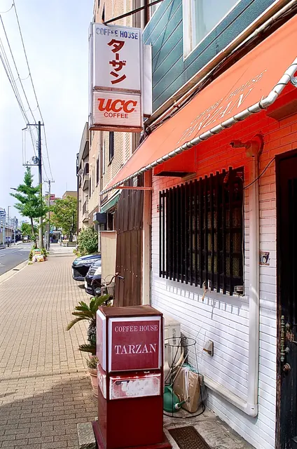 「COFFEE HOUSE ターザン」の看板と、赤い日よけの喫茶店