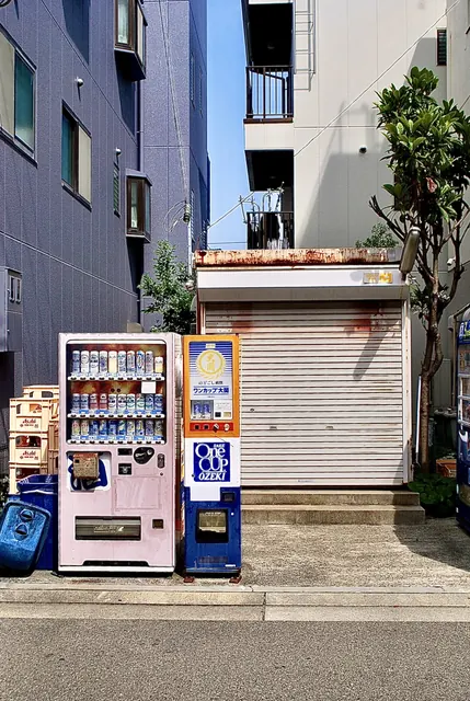 お酒の自動販売機と、さびたシャッターの小さな建物