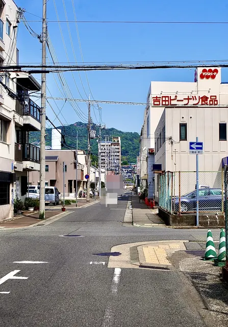 ピーナツの会社の看板の先に、山並みが見える通り