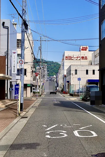 「ゾーン30」の文字の道の先に、山並みと家並みが見える風景