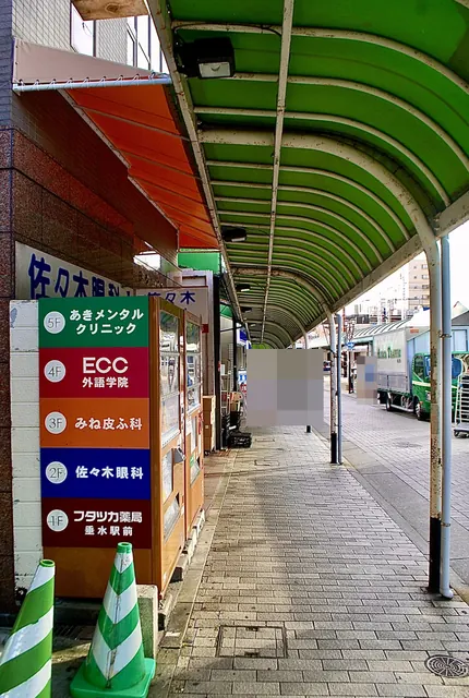 緑のアーケード屋根の下を、駅前の大通りに沿って続く歩道
