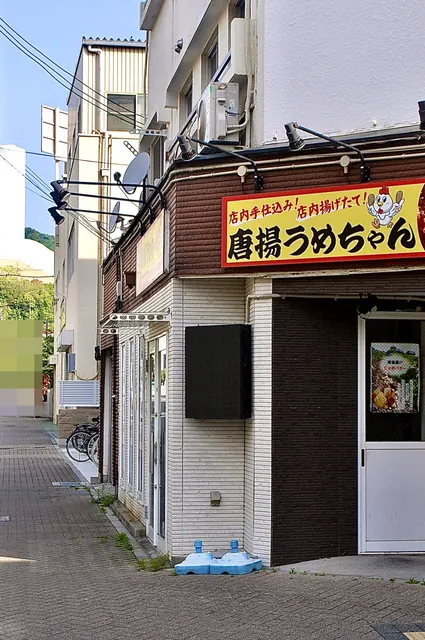 黄色い看板の「唐揚うめちゃん」と、並木の続く広い歩道
