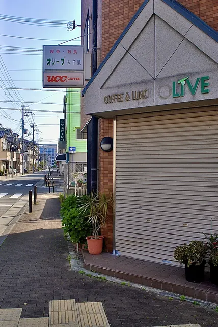 「COFFEE & LUNCH LIVE」の看板と、交差点の見える歩道