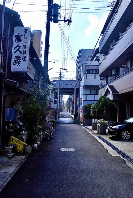 縦長の看板の店の前から、商店街の入口へまっすぐ続く道
