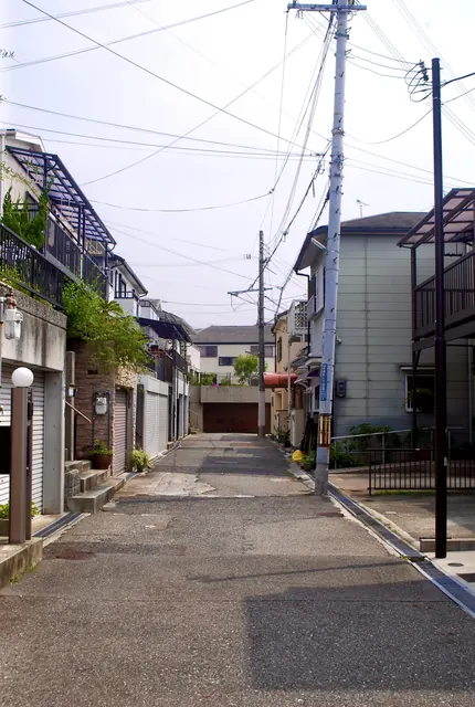 家々とガレージのあいだを、奥へ続く静かな住宅街の道