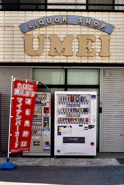 アーチ型の看板と、たばこ・お酒の自動販売機が並ぶ酒店