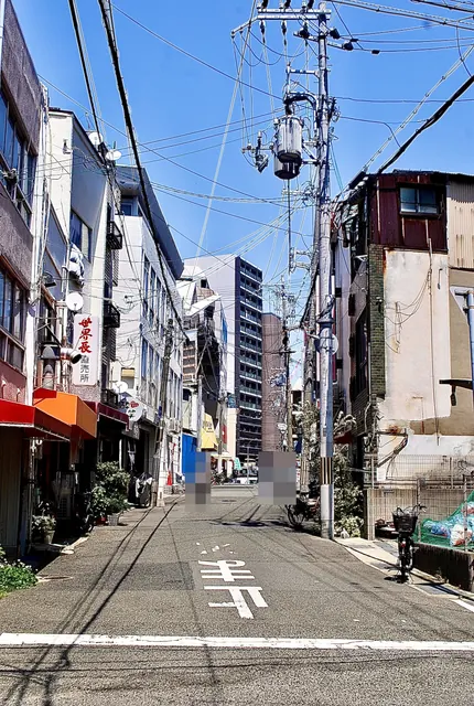 「世界長直売所」の看板と、色とりどりの日よけが並ぶ通り