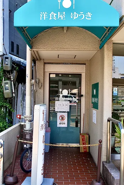 水色の日よけに「洋食屋 ゆうき」と書かれた、レトロな入口