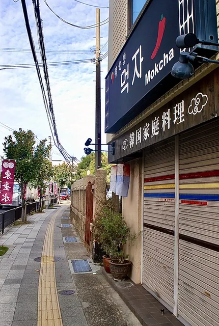 えんじ色の「東垂水」の幟が並ぶ、並木の歩道