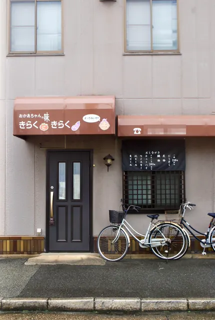 「おかあちゃんの味」の日よけと、おしながきの掛かる窓