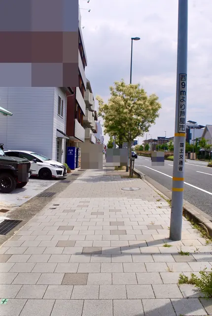 「芦屋市」の標識が立つ、並木の続く大通りの歩道