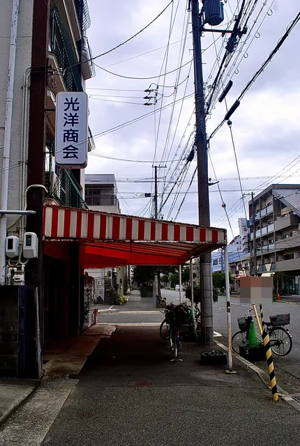 「光洋商会」の看板と、赤白のしましまの日よけ