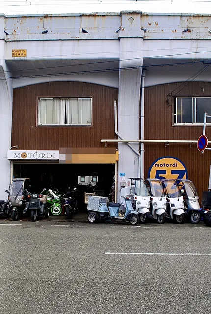 スクーターがずらりと並ぶ、木の壁のバイク屋