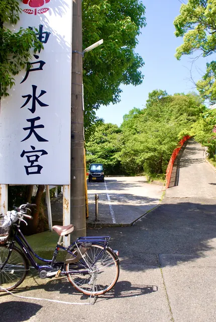 神戸水天宮の大きな看板の先に、緑に囲まれた道が続く風景