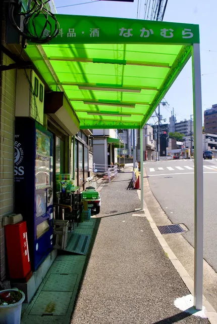 鮮やかな緑の屋根がかかる、角の食料品店