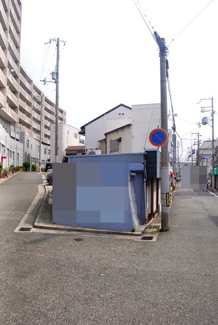 青い壁の小屋の前で分かれ、奥へまっすぐ続く道