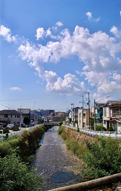 もくもくとした雲の広がる空の下を流れる川