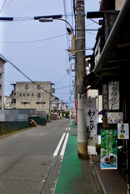 「わらびもち」「水まんじゅう」ののぼりと、緑の自転車道のある通り