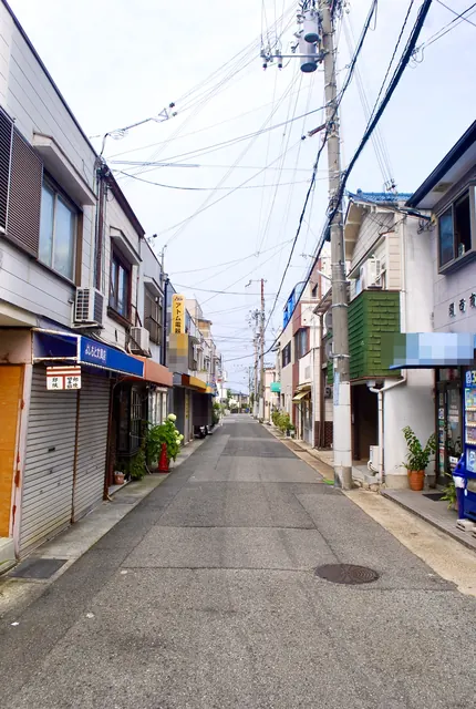文具店や電器店の看板が並ぶ、シャッターの続く通り