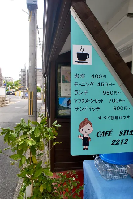 コーヒーの絵が描かれたカフェのメニュー看板と、奥へ続く通り