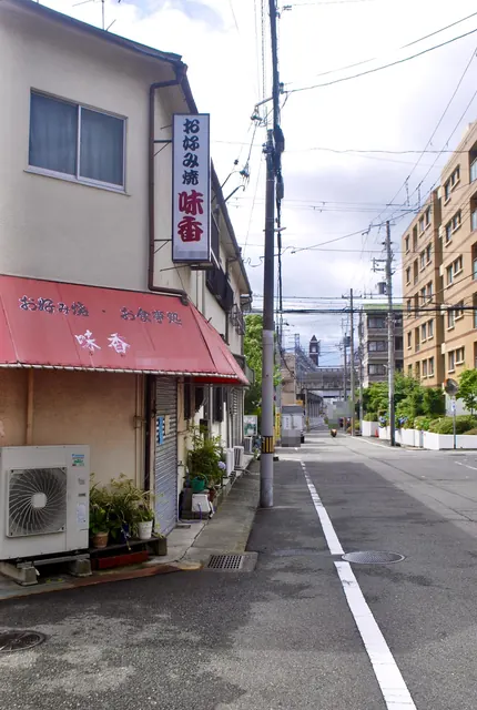 赤い日よけに「お好み焼・お食事処 味香」と書かれた角の店