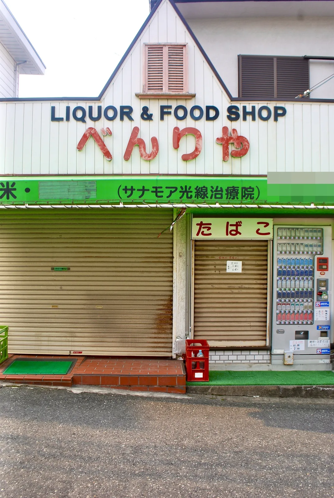 とんがり屋根に「LIQUOR & FOOD SHOP べんりや」の看板がある店