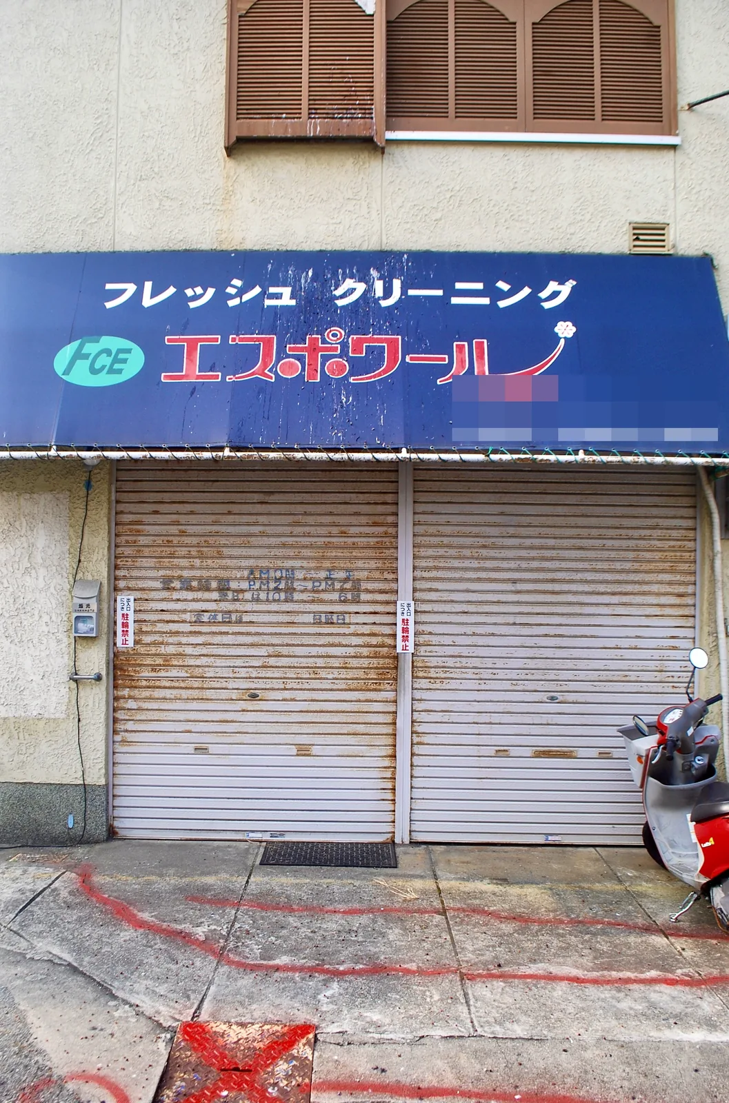 「フレッシュクリーニング エスポワール」の青い日よけと古いシャッター
