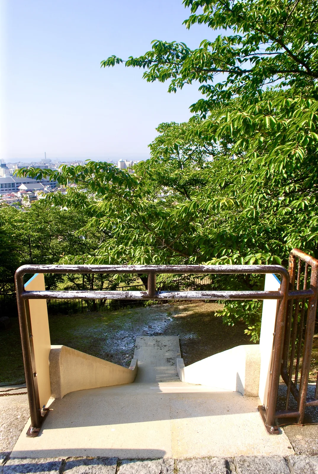 木々に囲まれた公園の、町を見下ろす手すり