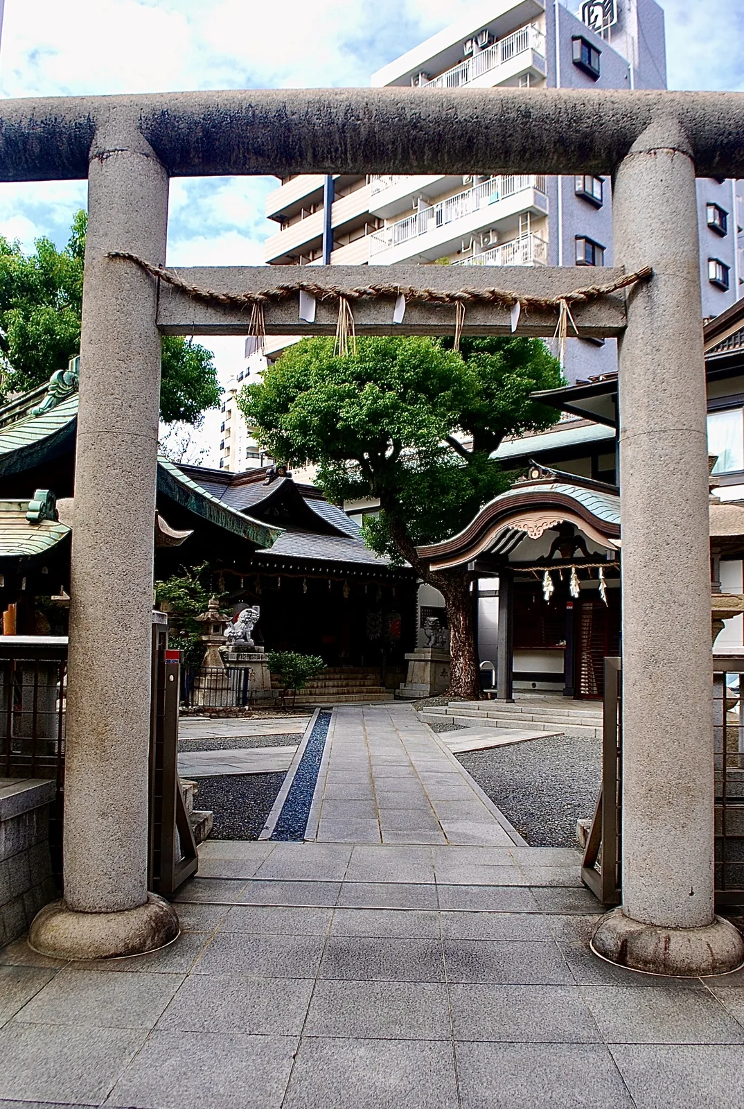 石の鳥居の先に、境内と社殿が見える神社