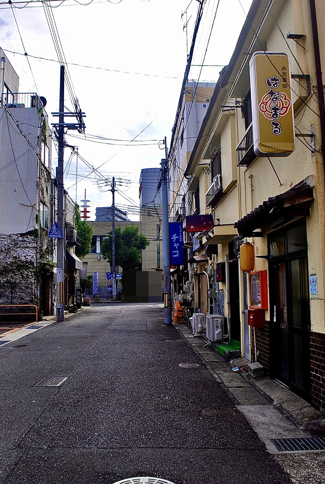 赤い提灯や看板の並ぶ店と、奥へ続く道