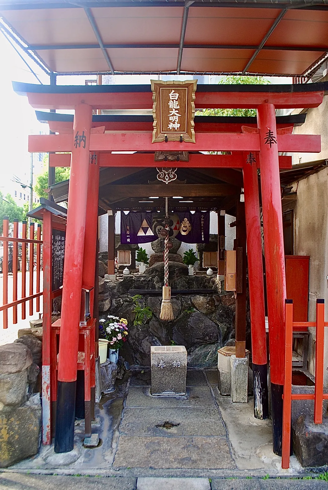 屋根の下に朱色の鳥居が並ぶ、白龍大明神の小さなお社