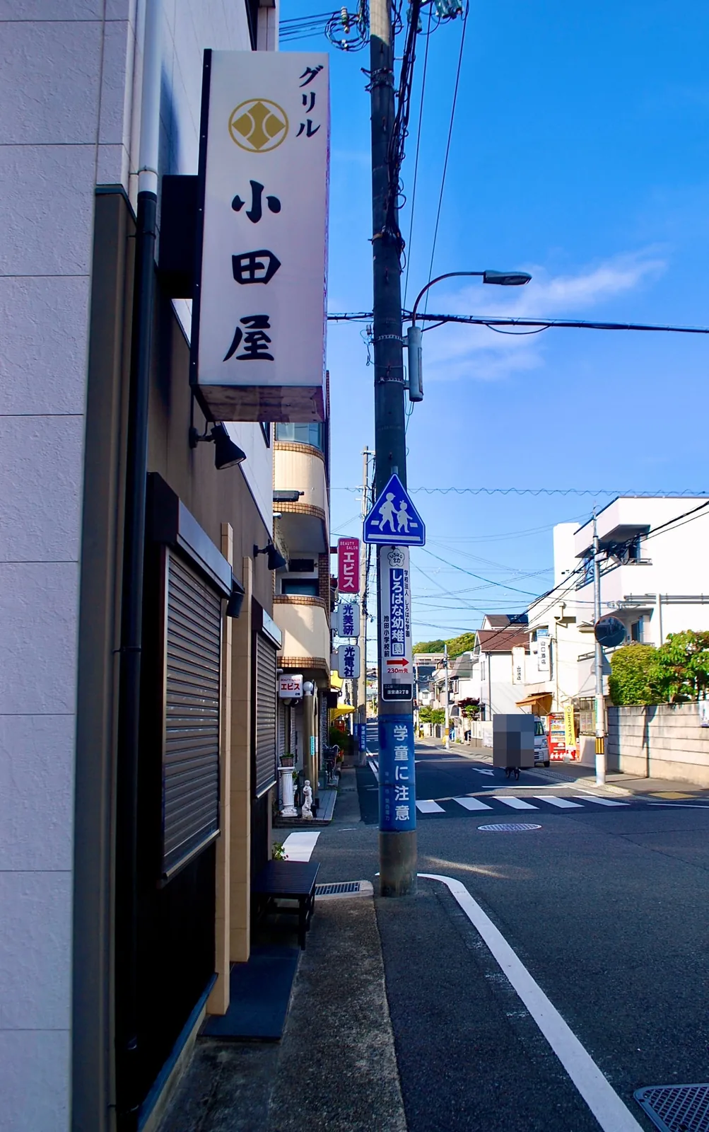 縦長の看板と電柱が並ぶ通り